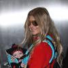 Fergie prend un vol à l'aéroport de Los Angeles avec son fils Axl, le 10 février 2014.