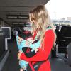 Fergie prend un vol à l'aéroport de Los Angeles avec son fils Axl, le 10 février 2014.
