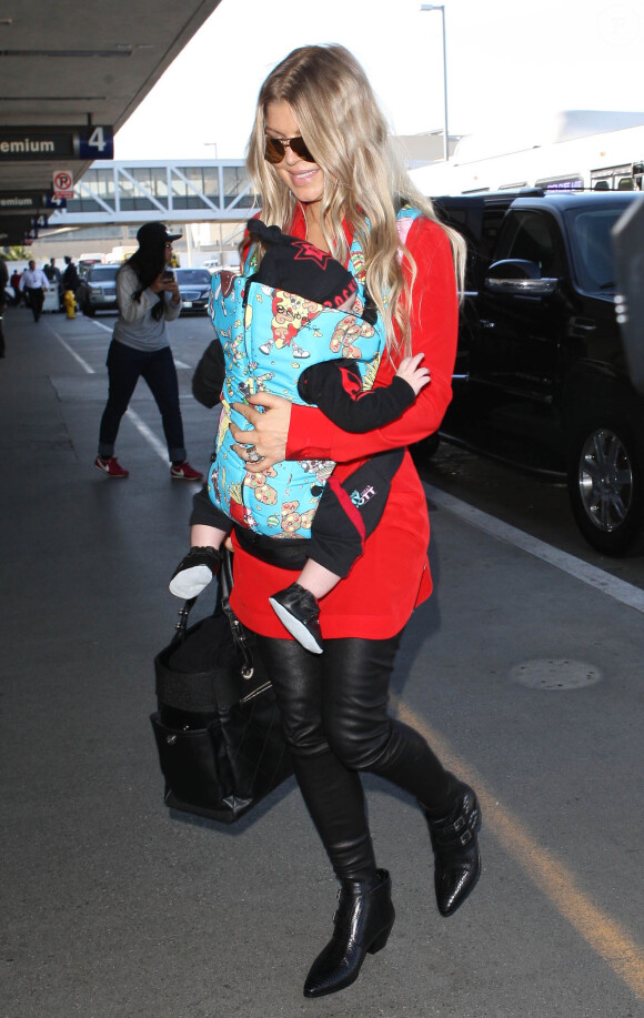 Fergie prend un vol à l'aéroport de Los Angeles avec son fils Axl, le 10 février 2014.