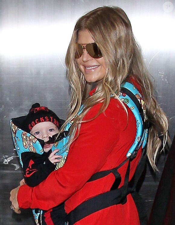 Fergie prend un vol à l'aéroport de Los Angeles avec son fils Axl, le 10 février 2014.