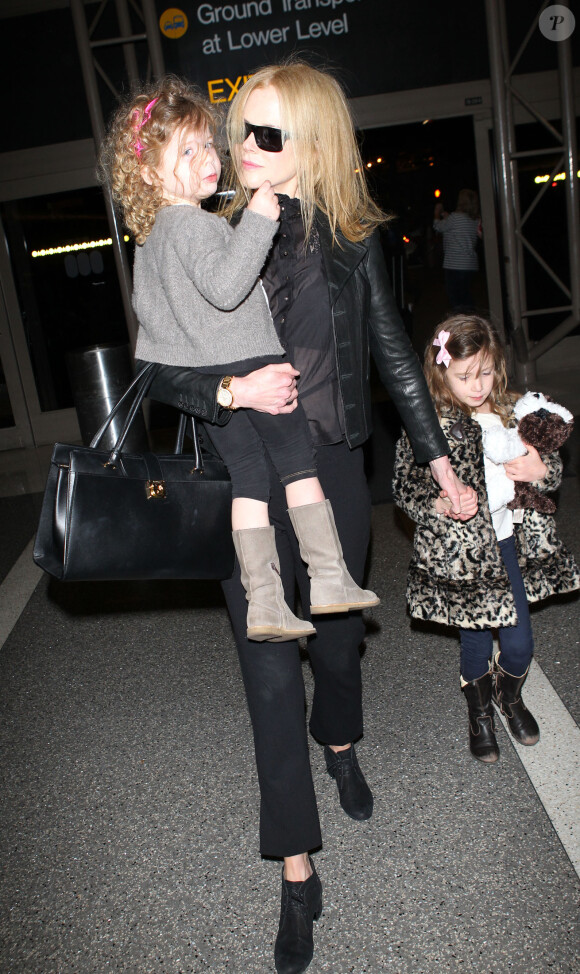 Nicole Kidman avec ses filles Faith (dans ses bras) et Sunday lui tenant la main, au LAX Airport, Los Angeles, le 26 mars 2014.