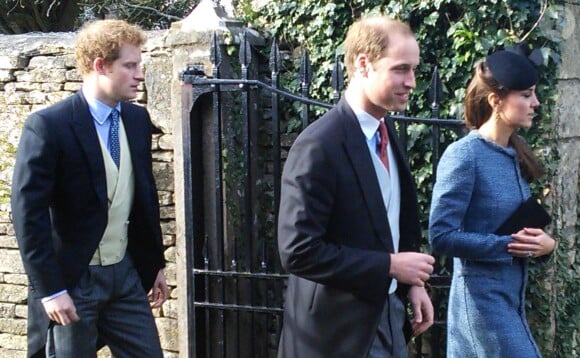 Le prince William et Kate Middleton, en manteau Missoni, suivis du prince Harry, au mariage de Lucy Meade et Charlie Budgett, le 29 mars 2014 à Marshfield, dans le Gloucestershire.
