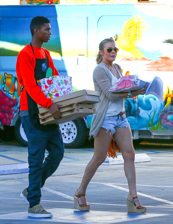 La chanteuse LeAnn Rimes et Eddie Cibrian chargent des cadeaux dans leur véhicule pour le fils de l'acteur, Jake, après une journée passée à Sky High Sports à Woodland Hills, Los Angeles, le 12 avril 2014.