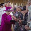 La reine Elizabeth II a remis à 88 femmes et 88 hommes méritants les pièces du Jeudi saint, le 17 avril 2014 à Blackburn, dans le Lancashire.