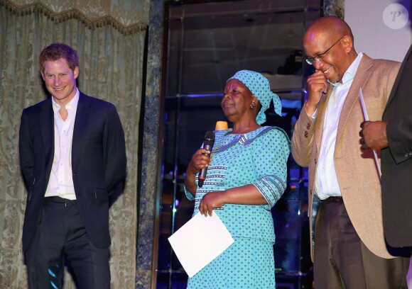Le prince Harry avec Malineo Motsephe, récompensée par un prix lors de la soirée Sentebale summer party au Dorchester Hotel à Londres le 7 mai 2014.