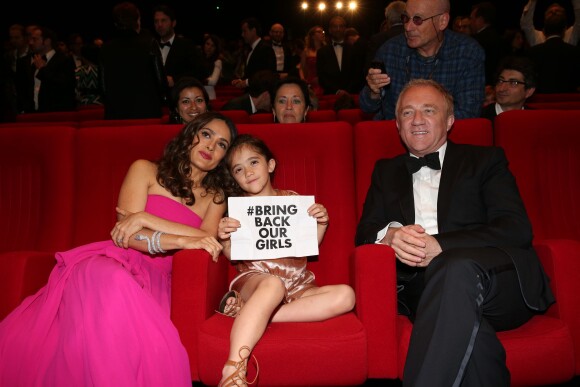 Salma Hayek, son mari François-Henri Pinault et leur fille Valentina Pinault (pancarte de soutien au lycéennes enlevées au Nigéria) lors de l'hommage au cinéma d'animation lors du 67e Festival du film de Cannes le 17 mai 2014.