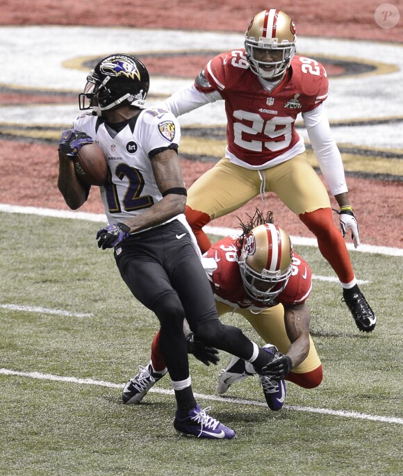 Jacoby Jones des Baltimore Ravens échappant à Dashon Goldson et Chris Culliver des San Francisco 49ers pour marquer son premier touchdown lors du Super Bowl XLVII à La Nouvelle-Orléans le 3 février 2013