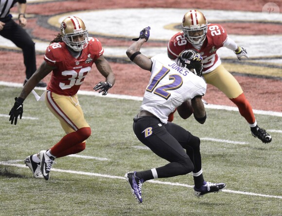 Jacoby Jones des Baltimore Ravens prêt à échapper à Dashon Goldson et Chris Culliver des San Francisco 49ers pour marquer son premier touchdown lors du Super Bowl XLVII à La Nouvelle-Orléans le 3 février 2013