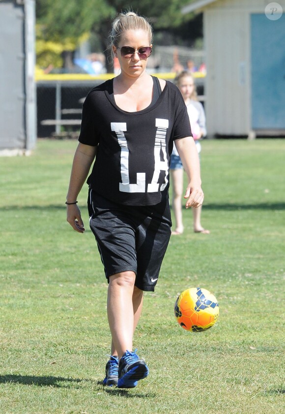 Kendra Wilkinson (enceinte) et son mari Hank Baskett encouragent leur fils Hank lors de son match de football à Woodland Hills, le 30 mars 2014.