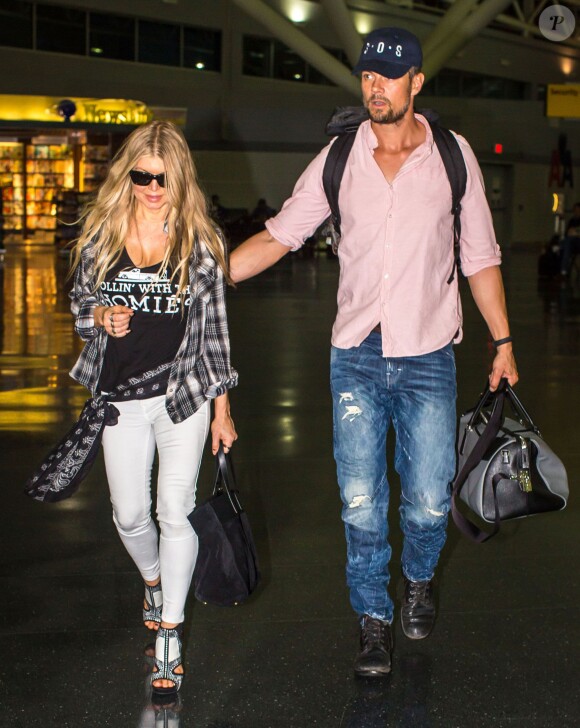 La chanteuse Fergie et son mari Josh Duhamel arrivent à l'aéroport de JFK à New York, le 9 juin 2014.