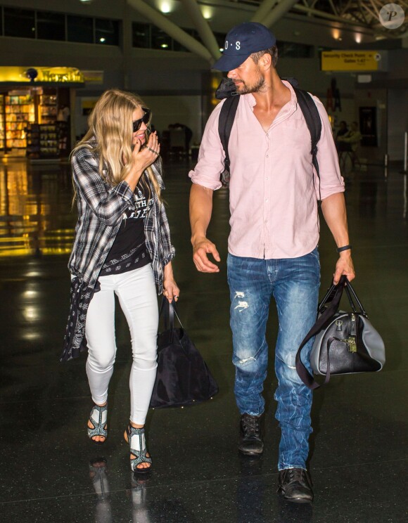 La chanteuse Fergie et son mari Josh Duhamel arrivent à l'aéroport de JFK à New York, le 9 juin 2014.