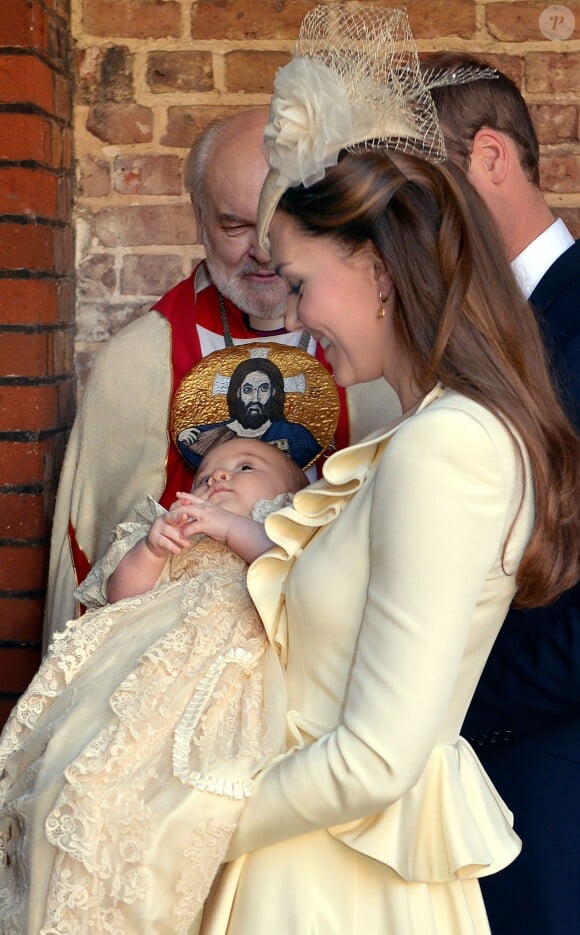 Un cup d'oeil en coin vers sa maman, une jolie robe baptismale historique, un air placide et une auréole en point de mire : le prince George de Cambridge prêt pour son baptême, le 23 octobre 2013 au palais St James, à Londres. Le fils du prince William et de Kate Middleton a eu 1 an le 22 juillet 2014.