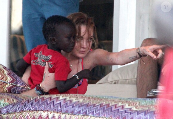 Lindsay Lohan joue avec un petit garçon pendant ses vacances à Mykonos en Grèce, le 7 août 2014.