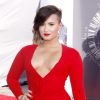 Demi Lovato assiste aux MTV Video Music Awards 2014 au Forum, habillée d'une robe rouge et décolletée Lanvin. Inglewood, le 24 août 2014.