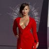 Demi Lovato, habillée d'une robe rouge décolletée et fendue Lanvin et d'une pochette Charlotte Olympia, assiste aux MTV Video Music Awards 2014 au Forum. Inglewood, le 24 août 2014.