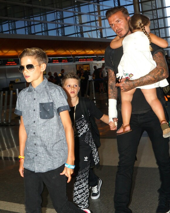 David Beckham, bandage à la main, à l'aéroport LAX de Los Angeles, avec ses enfants Romeo, Cruz et Harper avant de s'envoler pour Londres, le 29 août 2014