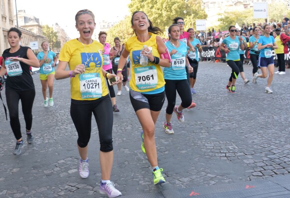 Fabienne Carat et sa soeur à fond lors de la course "La Parisienne 2014" pour la lutte contre le cancer, au Champs de Mars à Paris, le 14 septembre 2014