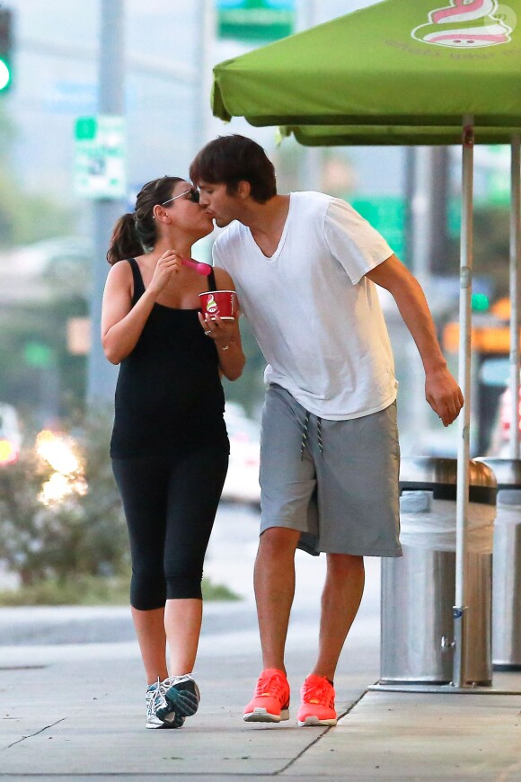 Ashton Kutcher et Mila Kunis s'embrassent à Sherman Oaks le 7 juin 2014.