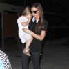 Victoria Beckham arrive avec ses enfants Romeo, Cruz, et Harper à Los Angeles le 16 octobre 2014. La styliste mise sur un look all black qu'elle twiste avec T-shirt au col Claudine qui lui donne un air preppy. Un carton look pour la créatrice qui va certainement transmettre son sens du style à sa poupée Harper.
