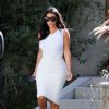 Kim Kardashian sort de chez des amis à Studio City, le 15 octobre 2014 dans un look estival. Moulée dans une tenue blanche, perchée sur ses escarpins Gianvito Rossi, la star de télé réalité reste sexy avec des pièces ultra-ajustées.