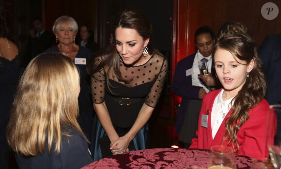 Kate Middleton, enceinte de quatre mois, discute avec la jeune Rienne Maine, à Kensington Palace, à Londres, le 19 novembre 2014. A deux pas de son domicile, la duchesse de Cambridge, en haut Hobbs et jupe Jenny Packham, remettait ce soir-là les prix de l'association Place2Be dont elle est la marraine depuis 2013.