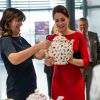 Kate Middleton découvre de la vaisselle vendue au profit de la campagne de l'EACH. La duchesse de Cambridge, enceinte de quatre mois, dévoilait ses rondeurs dans une robe Katherine Hooker alors qu'elle se mobilisait le 25 novembre 2014 à Norwich, dans le Norfolk, pour lancer une levée de fonds en vue de construire un nouvel hôpital pour enfants de l'organisme East Anglia Children's Hospices.