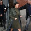 Kim Kardashian quitte l'appartement de son mari Kanye West à New York, habillée d'un trench-coat en cuir Lanvin kaki, d'une robe assortie Kardashian Kollection et de sandales Hermès. Le 10 décembre 2014.