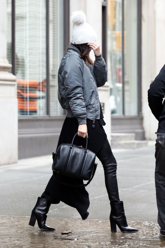 Kendall Jenner à New York, porte un bomber gris dérivé du Yeezus Tour, un sac Givenchy (modèle Lucrezia) et des bottines Céline. Le 10 décembre 2014.