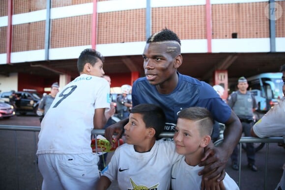 Paul Pogba avec des enfants avant l'entraînement de l'équipe de France à Ribeirao Preto au Brésil le 17 juin 2014