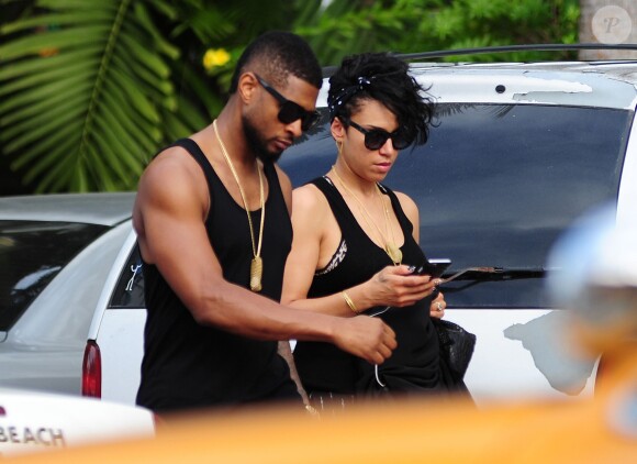 Usher se promène avec sa compagne Grace Miguel dans les rues de Miami. Le 15 décembre 2014  