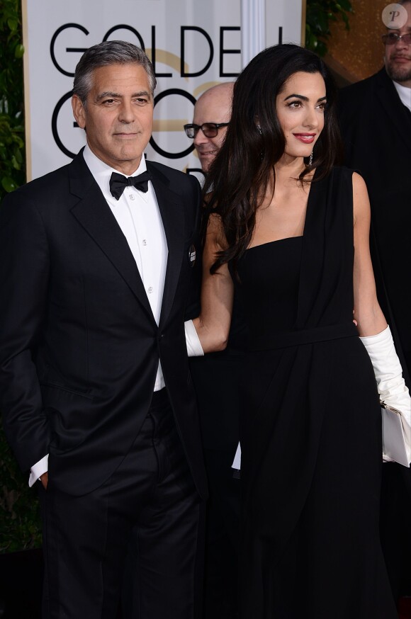 George Clooney (en Armani) et sa femme Amal Alamuddin Clooney (en Dior) lors des Golden Globes Awards à Los Angeles le 11 janvier 2015