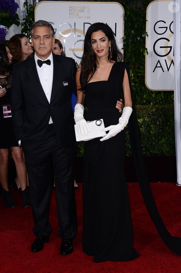 George Clooney (en Armani) et sa femme Amal Alamuddin Clooney (en Dior) lors des Golden Globes Awards à Los Angeles le 11 janvier 2015