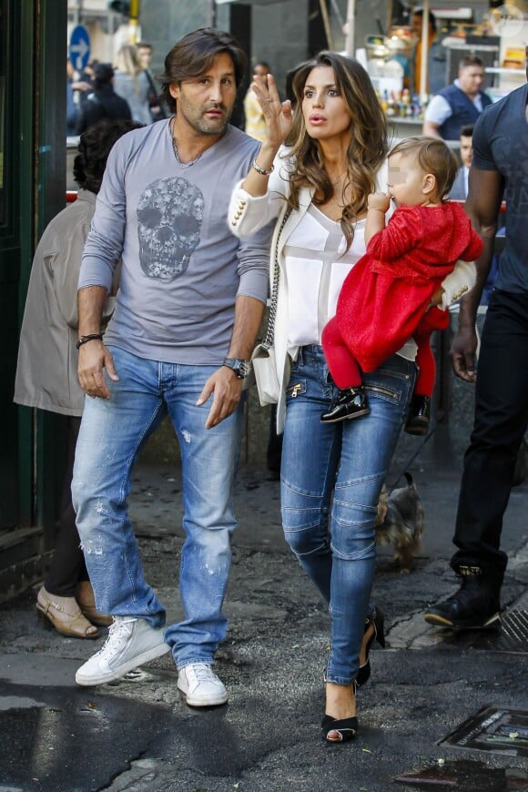 Claudia Galanti, enceinte d'Indila et avec sa fille Tal dans les bras, avec Arnaud Mimran dans les rues de Milan lors de la Fashion Week, le 18 septembre 2013.