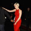 Miley Cyrus dans une jolie robe rouge s'accroche à son garde du corps alors qu'elle quitte le bar à cocktails Hooray Henry's à Los Angeles avec son petit ami Patrick Schwarzenegger, le 7 février 2015.
