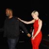 Miley Cyrus dans une belle robe rouge s'accroche à son garde du corps alors qu'elle quitte le bar à cocktails Hooray Henry's à Los Angeles avec son petit ami Patrick Schwarzenegger, le 7 février 2015.