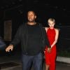 Miley Cyrus dans une belle robe rouge s'accroche à son garde du corps alors qu'elle quitte le bar à cocktails Hooray Henry's à Los Angeles avec son petit ami Patrick Schwarzenegger, le 7 février 2015.