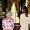 Kate Middleton observant avec la reine Elizabeth II son gâteau de mariage, réalisé par Fiona Cairns, exposé à Buckingham en juillet 2011