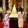 Kate Middleton observant avec la reine Elizabeth II son gâteau de mariage, réalisé par Fiona Cairns, exposé à Buckingham en juillet 2011