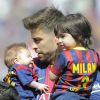 Gerard Piqué avec ses fils Milan (2 ans) et Sasha (3 mois) dans les bras lors du match FC Barcelone - FC Valence le 18 avril 2015 au Camp Nou.