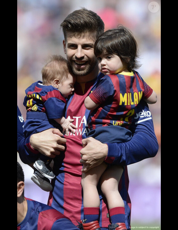 Gerard Piqué avec ses deux garçons Milan (2 ans) et Sasha (3 mois) dans les bras lors du match FC Barcelone - FC Valence le 18 avril 2015 au Camp Nou, auquel Shakira assistait.