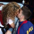 Shakira embrasse Gerard Piqué au Camp Nou le 18 avril 2015 lors du match FC Barcelone - FC Valence. Aidée par sa belle-mère Montserrat Bernabeu, elle était venue avec ses enfants Milan (2 ans) et Sasha (3 mois) encourager son chéri.