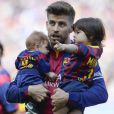Gerard Piqué avec ses deux garçons Milan (2 ans) et Sasha (3 mois) dans les bras lors du match FC Barcelone - FC Valence le 18 avril 2015 au Camp Nou, auquel Shakira assistait.