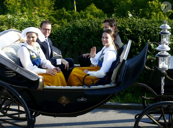 La princesse Victoria de Suède, le prince Daniel, Sofia Hellqvist et le prince Carl Philip partageaient la même calèche lors de la procession vers Skansen pour la Fête nationale, le 6 juin 2015.