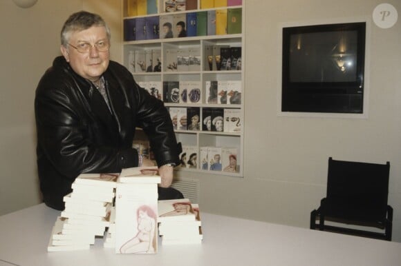 Archives - Jean Vautrin, (Jean Herman), écrivain, réalisateur devant une bibliothèque avec ses livres à Paris en mars 1989.