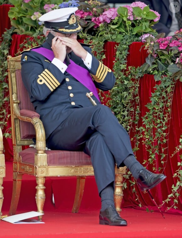 Le prince Laurent de Belgique au téléphone durant le défilé militaire de la Fête nationale, le 21 juillet 2015 à Bruxelles.