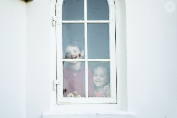 Henrik et Athena ont observé les photographes par la fenêtre avant de sortir. Le prince Henrik de Danemark, 6 ans, fils du prince Joachim et de la princesse Marie, faisait le 14 août 2015 sa pré-rentrée en classe 0 à l'Institukt Sankt Joseph de Copenhague, une école privée catholique située dans le quartier d'Østerbro. Le couple princier avait donné rendez-vous à la presse pour leur départ de leur domicile de Klampenborg, avec également la princesse Athena et Apple, le bichon frisé de Marie.