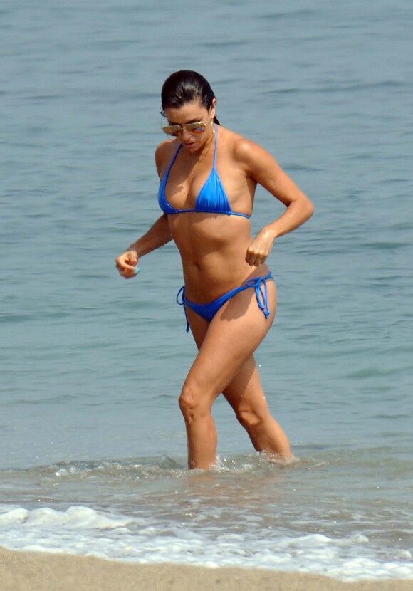 Eva Longoria se baigne à Marbella, habillée d'un bikini bleu Mikoh et de lunettes de soleil Victoria Beckham. Le 3 juillet 2015.