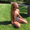 Beyoncé prend un bain de soleil, habillée d'un maillot découpé Stella McCartney. Juin 2015.