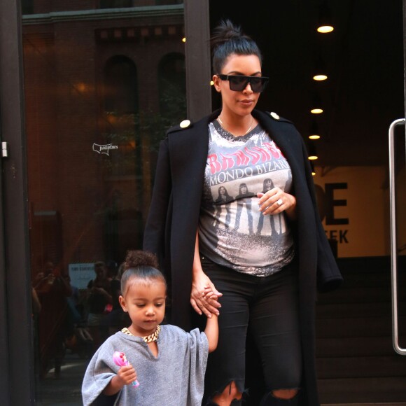 Kim Kardashian, enceinte, et sa fille North West (2 ans) quittent les studios de la Made Fashion Week à New York, le 7 septembre 2015.