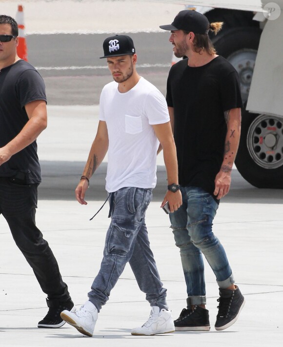 Harry Styles, Liam Payne, Louis Tomlinson, et Niall Horan du groupe One Direction montent à bord d'un jet privé à l'aéroport de Van Nuys, le 21 juillet 2015.